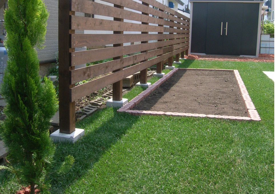 裏庭を芝生とコンクリート平板工事、木格子塀部分の写真（札幌市西区）